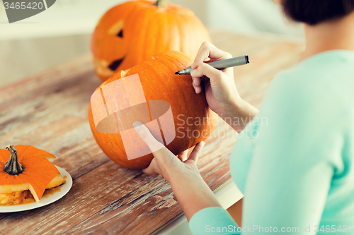 Image of close up of woman with pumpkins at home