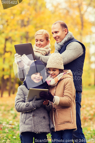 Image of happy family with tablet pc in autumn park