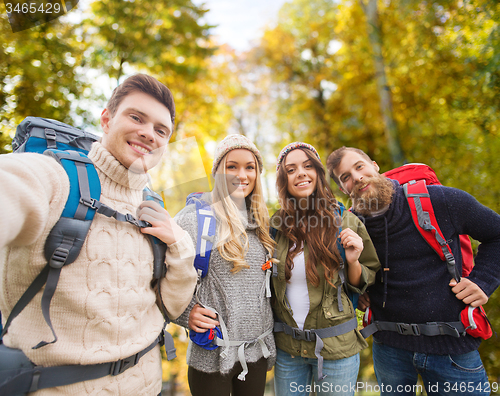 Image of group of smiling friends with backpacks hiking