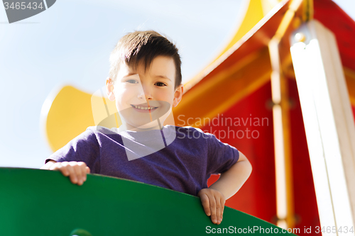 Image of happy little boy climbing on children playground