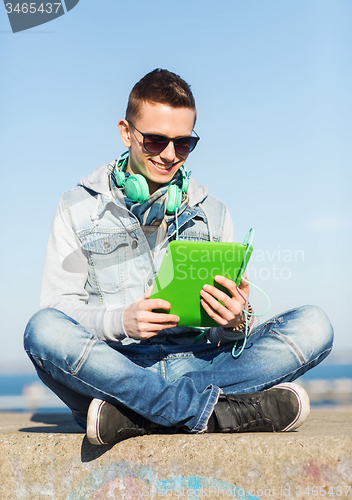 Image of happy young man with tablet pc and headphones