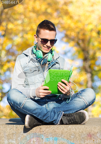 Image of happy young man with tablet pc and headphones