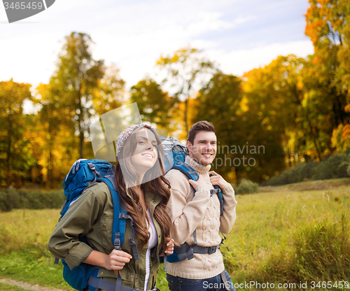 Image of smiling couple with backpacks hiking