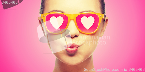 Image of girl in pink sunglasses blowing kiss