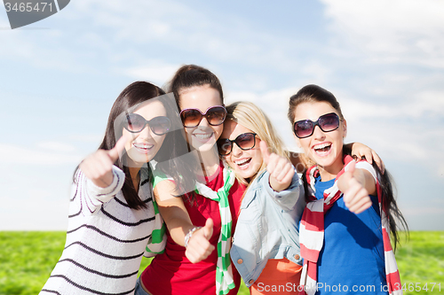 Image of happy teenage girls showing thumbs up at summer