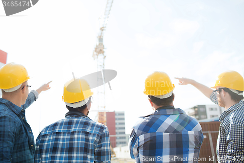 Image of group of builders in hardhats at construction site