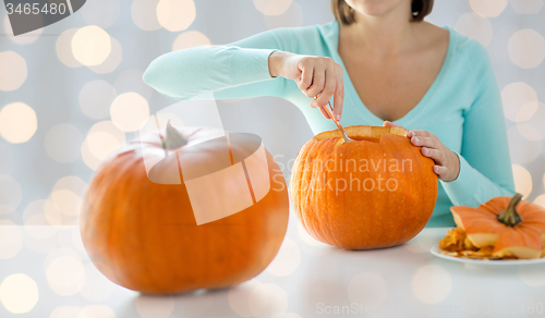 Image of close up of woman carving pumpkins for halloween