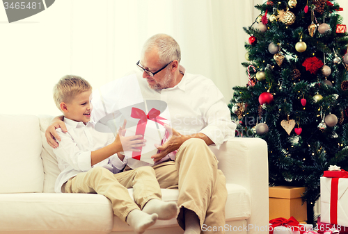 Image of smiling grandfather and grandson at home