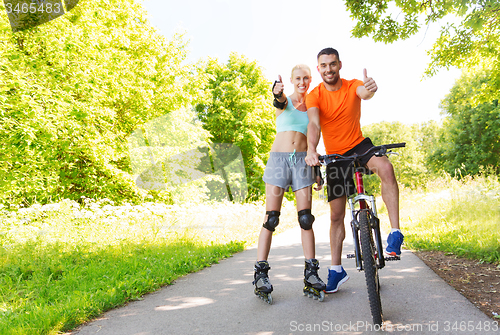 Image of couple on rollerblades and bike showing thumbs up