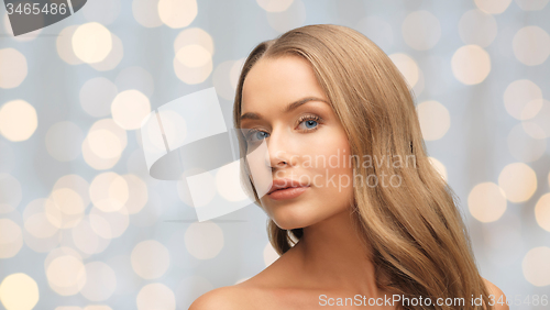 Image of beautiful young woman face over holidays lights