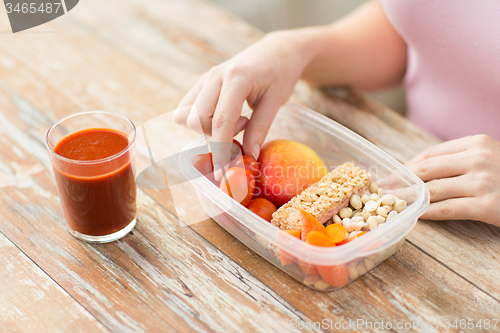 Image of close up of woman with vegetarian food in box