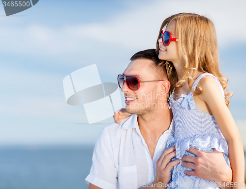 Image of happy father and child in sunglasses over blue sky