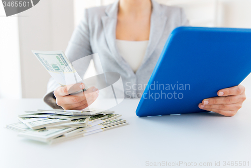 Image of close up of woman hands with tablet pc and money