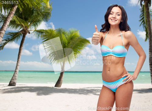 Image of happy woman in swimsuit showing thumbs up
