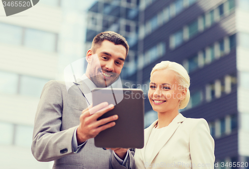 Image of smiling businessmen with tablet pc outdoors