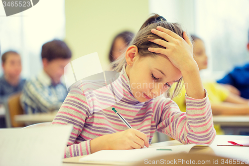 Image of group of school kids writing test in classroom