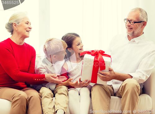 Image of smiling family with gifts at home