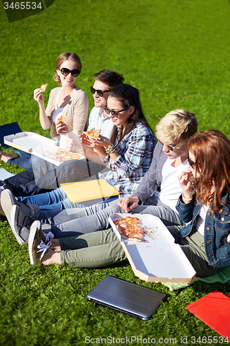 Image of group of teenage students eating pizza on grass
