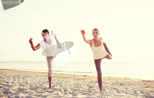 Image of couple making yoga exercises outdoors