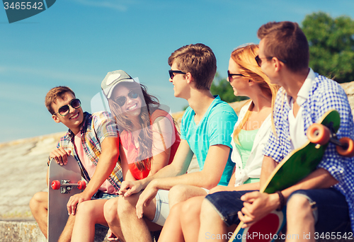 Image of group of smiling friends sitting on city street