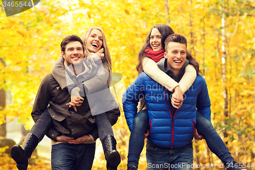 Image of smiling friends having fun in autumn park