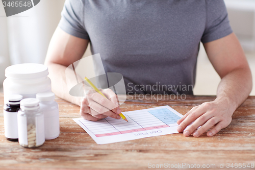 Image of close up of man with protein jars and diet plan