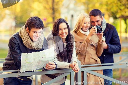 Image of group of friends with map and camera outdoors