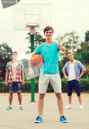 Image of group of smiling teenagers playing basketball