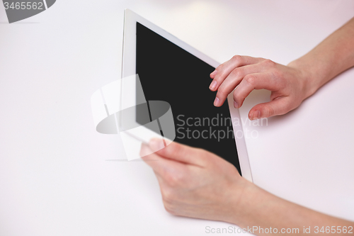 Image of close up of female hands with tablet pc at table