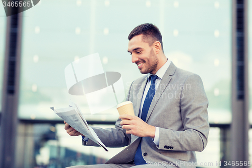 Image of young businessman with coffee and newspaper