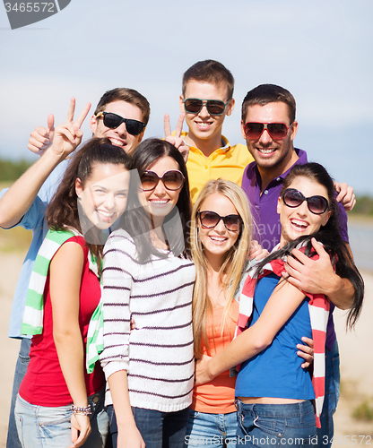 Image of group of happy friends having fun on beach