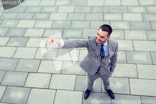 Image of young smiling businessman outdoors from top