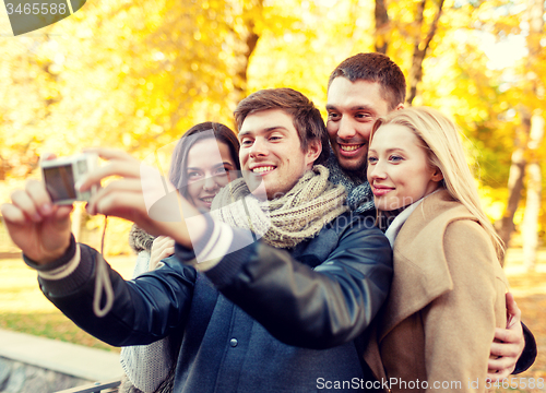 Image of group of smiling men and women making selfie