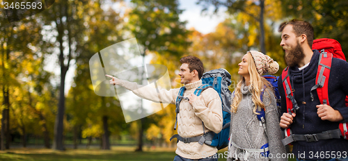 Image of group of smiling friends with backpacks hiking