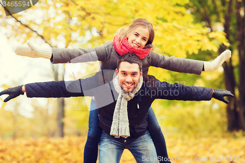 Image of smiling couple having fun in autumn park