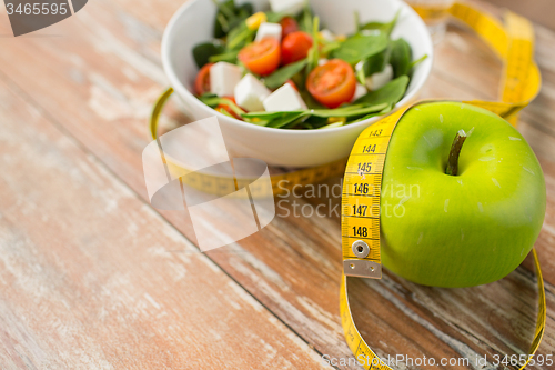 Image of close up of green apple and measuring tape