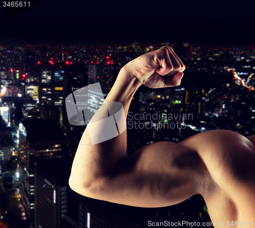 Image of close up of young man showing biceps