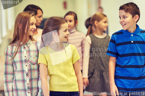 Image of group of smiling school kids walking in corridor