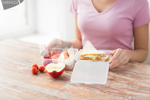 Image of close up of woman with food in plastic container