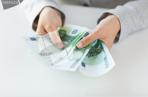 Image of close up of woman hands counting euro money