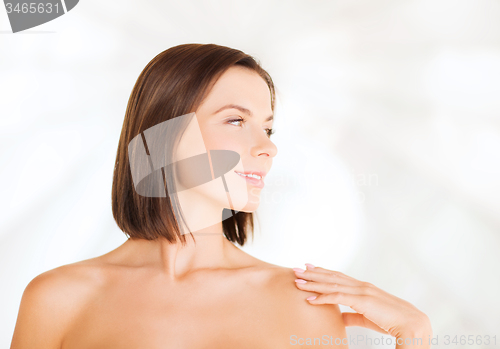 Image of beautiful woman touching her shoulders