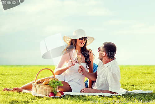 Image of smiling couple drinking champagne on picnic