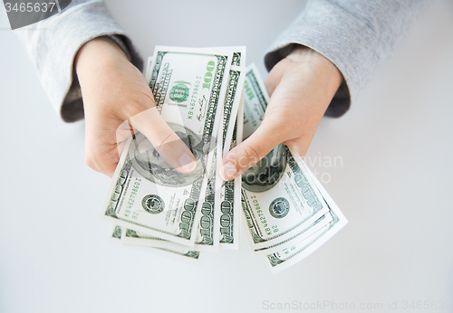 Image of close up of woman hands counting us dollar money