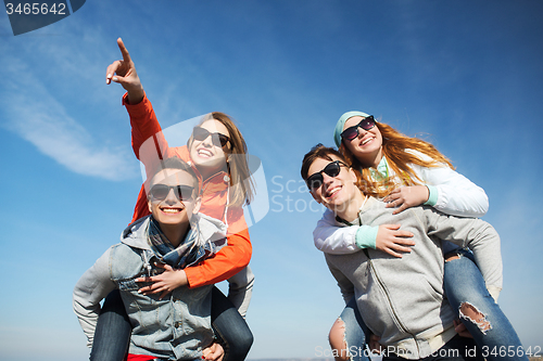 Image of happy friends in shades having fun outdoors