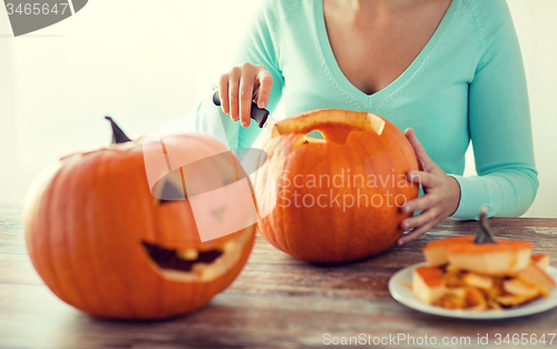 Image of close up of woman with pumpkins at home