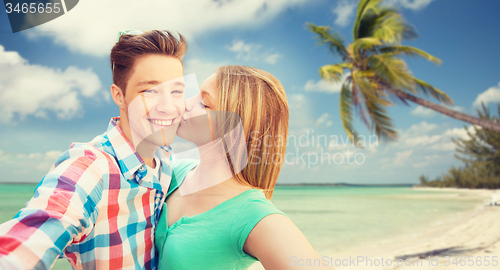 Image of happy couple taking selfie on tropical beach