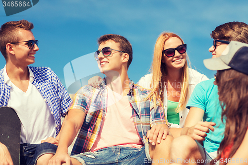 Image of group of smiling friends sitting on city street