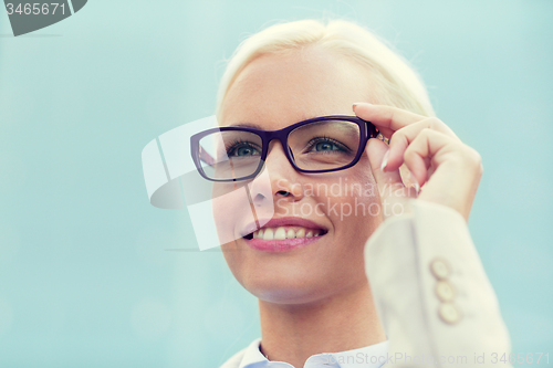 Image of young smiling businesswoman over office building