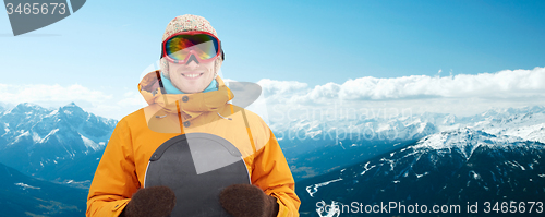 Image of happy young man in ski goggles over mountains