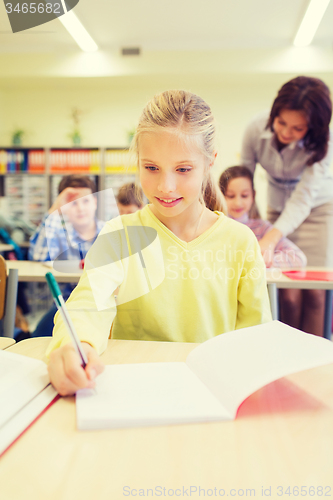 Image of group of school kids writing test in classroom